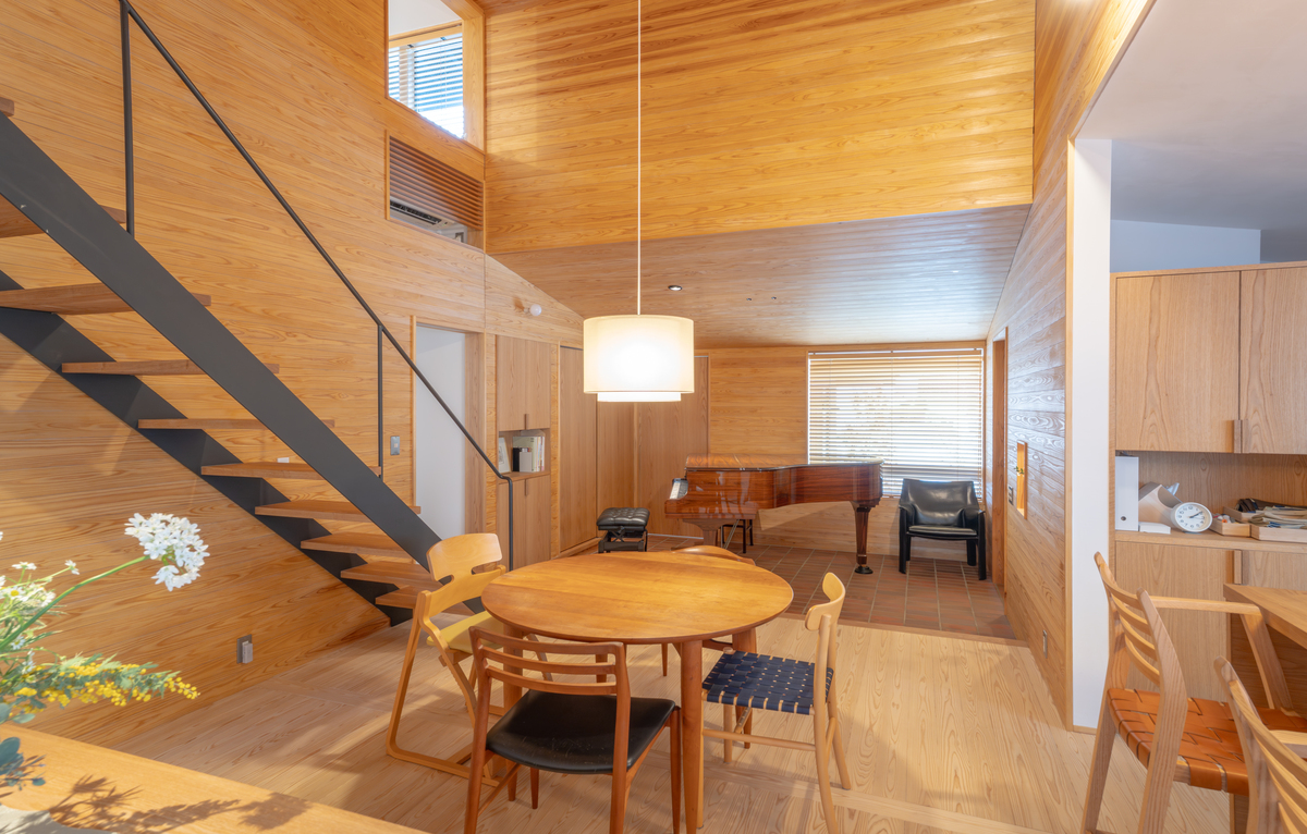 家の中心にあるダイニングは天井が高く吹き抜け、床・壁はスギ張り