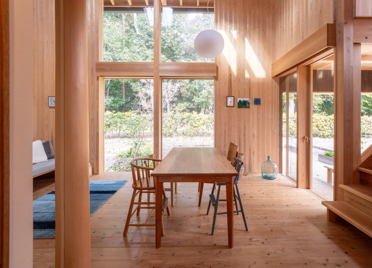 窓の外の豊かな緑と室内のスギが調和する眺め