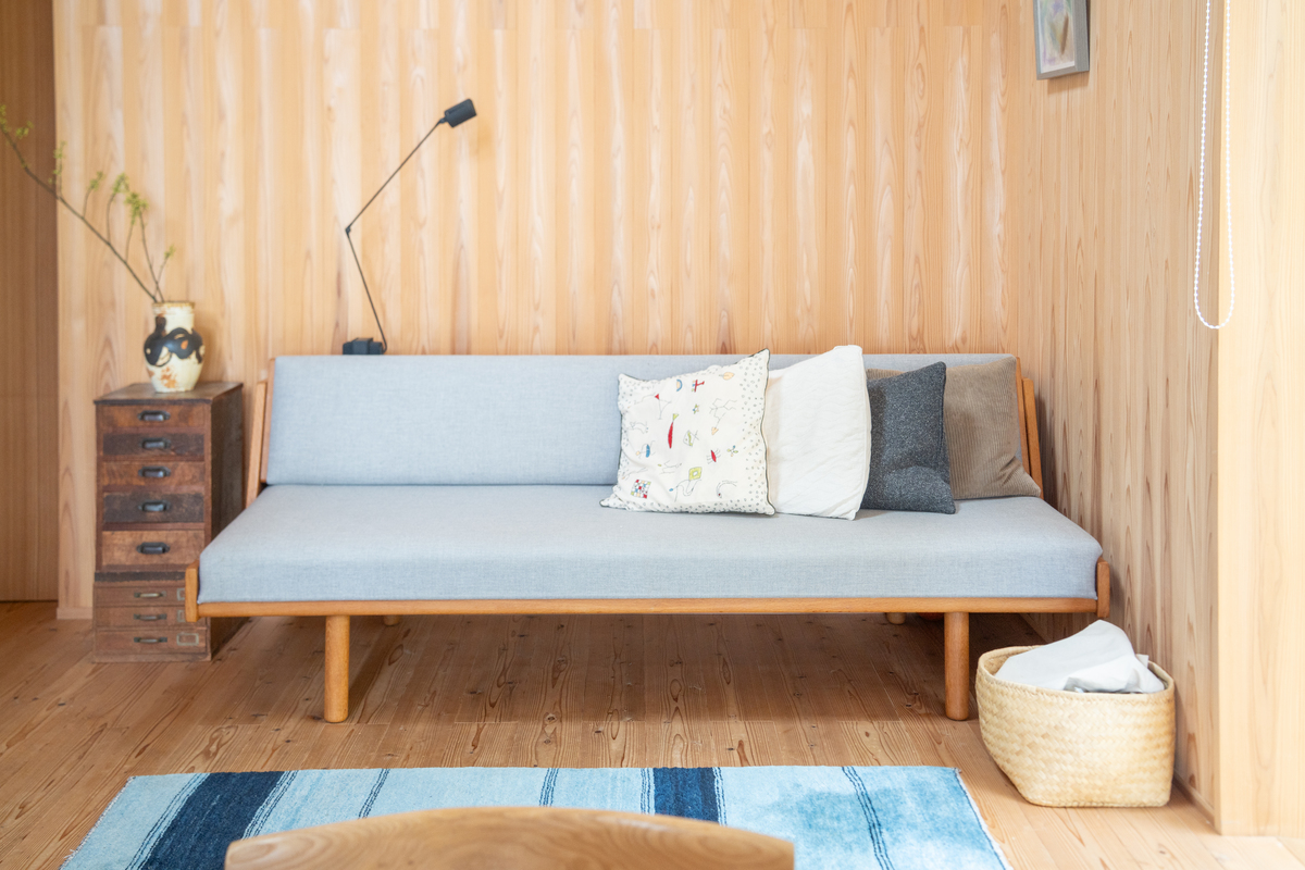 節のないスギの壁に溶け込む北欧家具や古い和家具