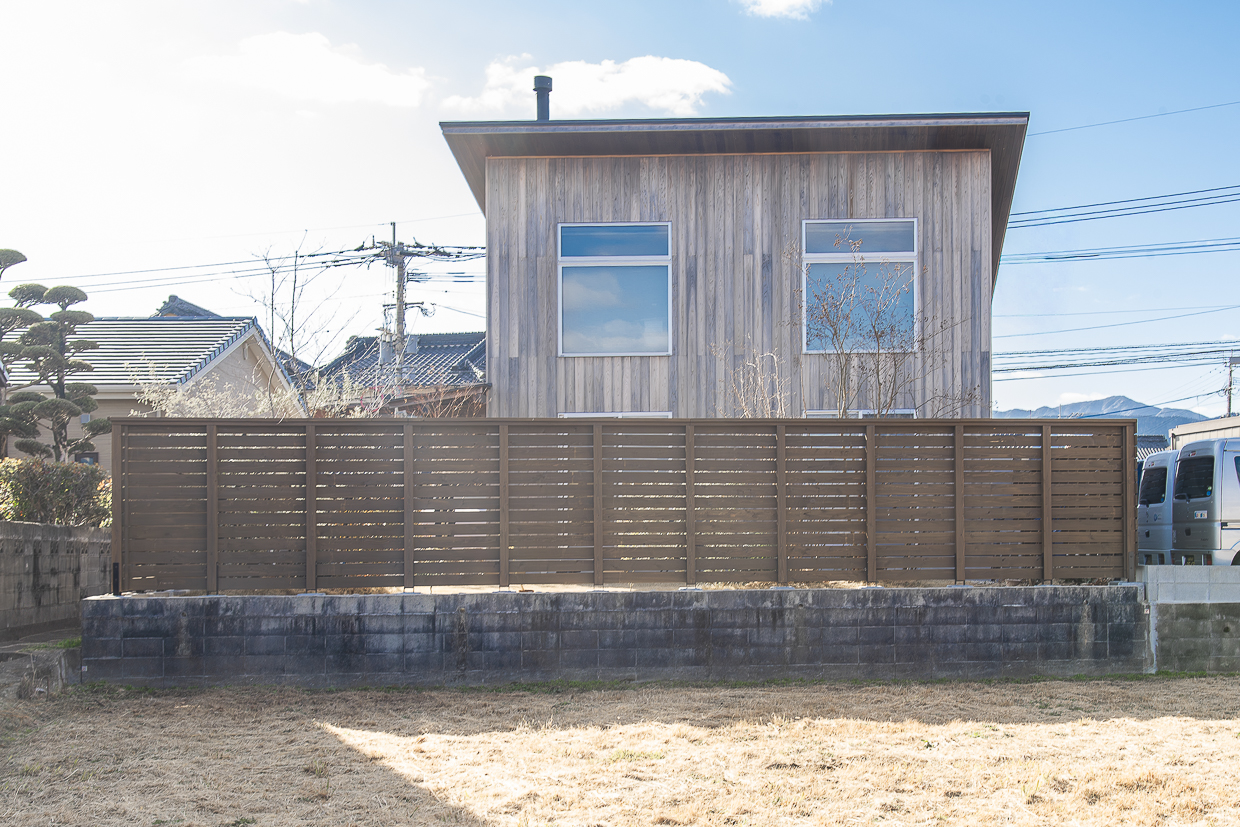 エイジングを感じさせる家の外壁にウッドフェンスがマッチしている