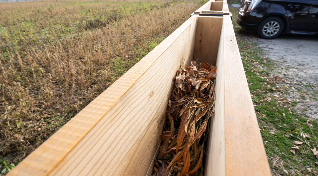 落ち葉は板と板の間に入れ、土を混ぜておけば堆肥になる